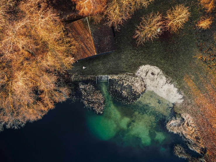 an aerial view of a body of water surrounded by trees, by Sebastian Spreng, unsplash contest winner, hurufiyya, near a jetty, thumbnail, switzerland, late autumn
