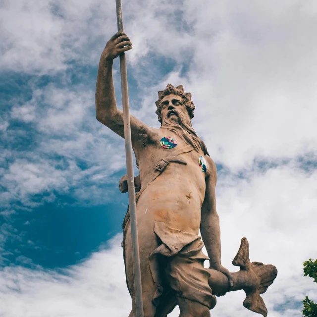 a statue of a man holding a flag, a statue, by Juan Giménez, pexels contest winner, neoclassicism, legendary god holding spear, viewed from the ground, traditional corsican, cloud goddess