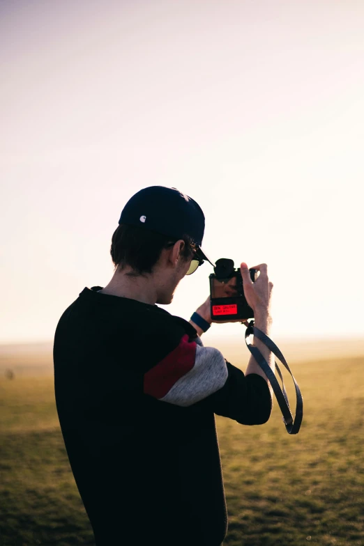 a man taking a picture of a horse in a field, a picture, unsplash contest winner, visual art, looking onto the horizon, vhs colour photography, overexposed flash, standing on a hill
