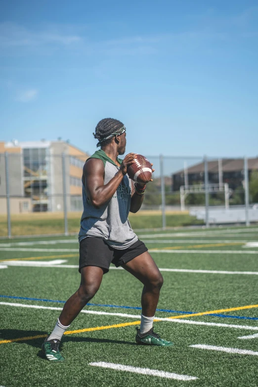 a man holding a football on top of a field