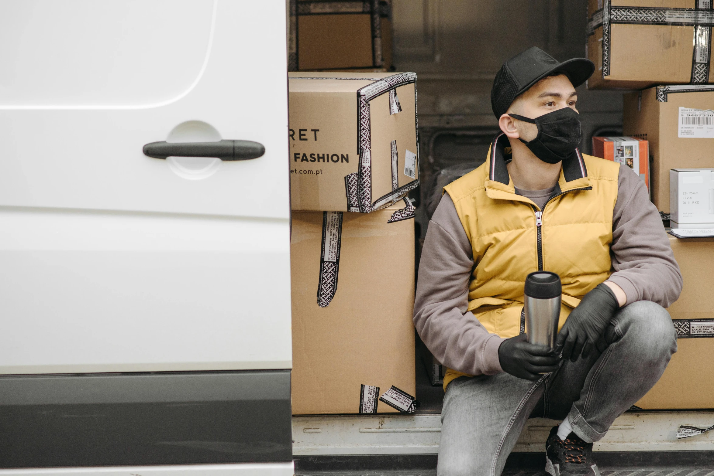 a man wearing a face mask sitting in the back of a van, pexels contest winner, renaissance, working clothes, avatar image, ecommerce photograph, commercial banner