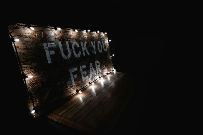 a lighted sign that says fuck you fear, an album cover, inspired by Elsa Bleda, trending on pexels, horror wallpaper aesthetic, a wooden, night photo, ahegao
