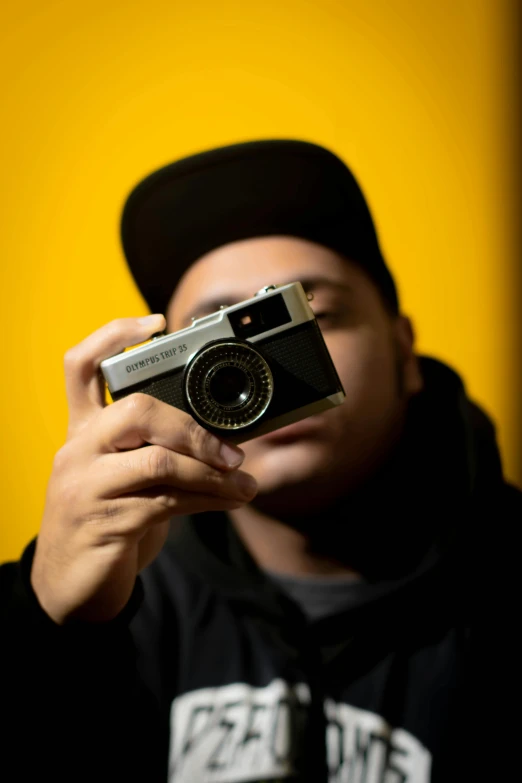 a man taking a picture with a camera, by Ric Estrada, avatar image, rapper, fujifilm x100v, icon