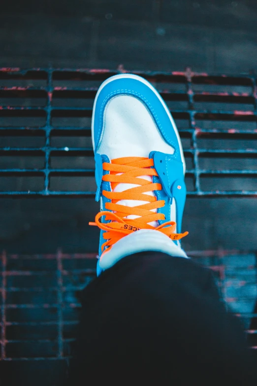a person wearing a pair of blue and orange sneakers, inspired by Jordan Grimmer, unsplash contest winner, renaissance, white neon, “air jordan 1, low detailed, headshot