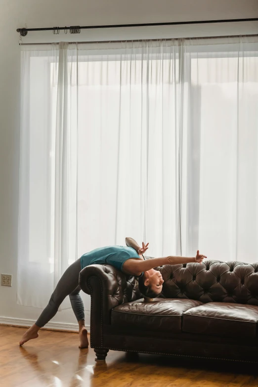 a woman laying on top of a couch in a living room, arabesque, yoga pose, david kassan, dabbing, profile image