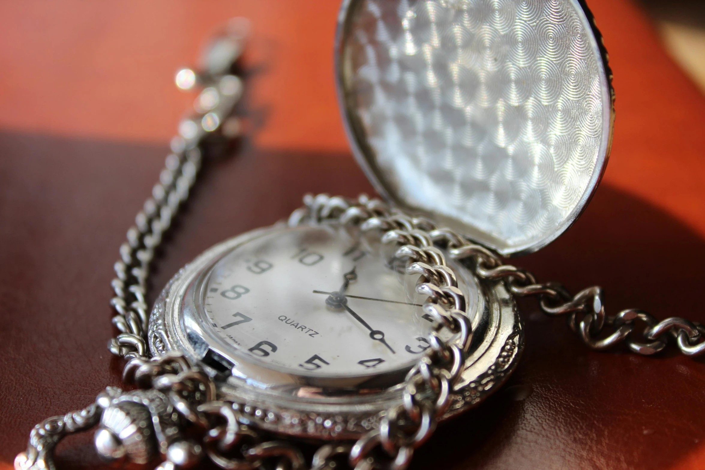 a close up of a pocket watch on a table, an album cover, shiny silver, thumbnail, detailed jewellery, chain mail