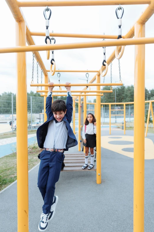 a boy on a monkey bars in a park, an album cover, pexels, school uniform, gettyimages, square, playground