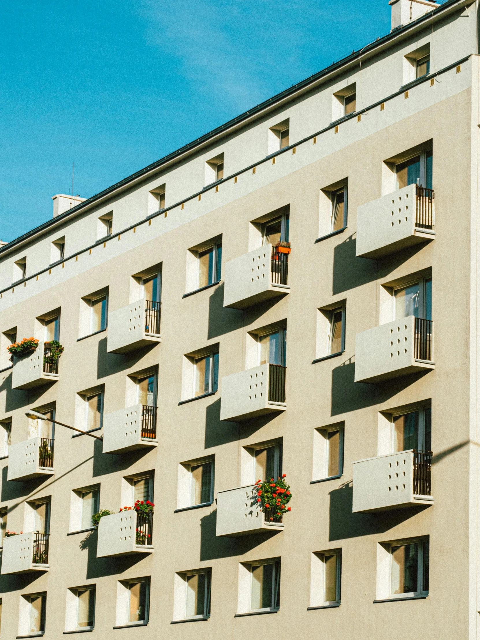 an apartment building with balconies on the balconies, by Kristian Zahrtmann, pexels contest winner, modernism, white panels, youtube thumbnail, wes anderson style, low quality photo