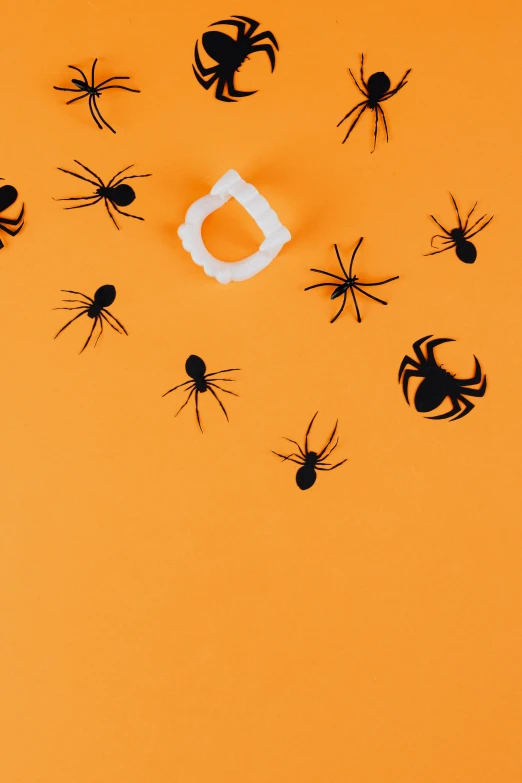 a group of black spiders on an orange background, interactive art, paper decoration, dark. no text, chalk, full product shot