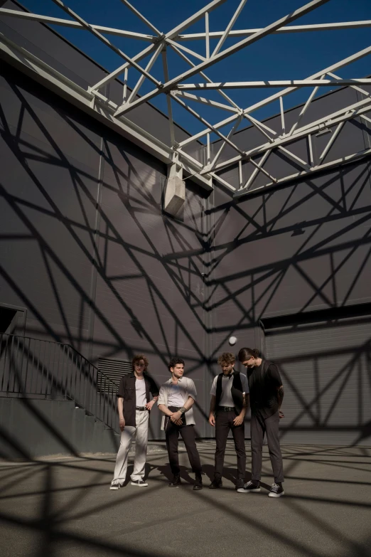 a group of young men standing next to each other, an album cover, bauhaus, geodesic building, back lit, atrium, rooftop