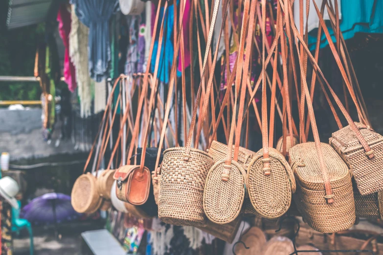 a bunch of baskets hanging from the side of a building, a picture, trending on unsplash, arts and crafts movement, handbag, inside an arabian market bazaar, straps, bali