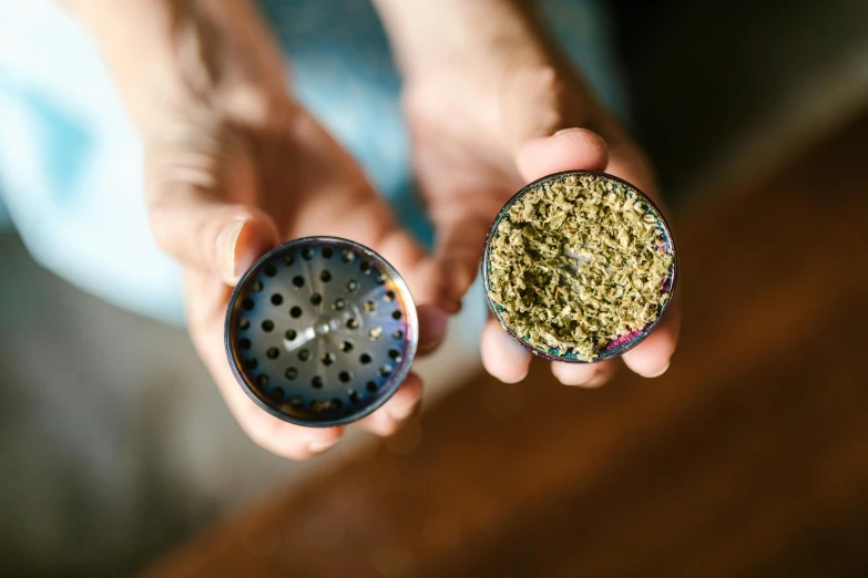 a person holding a salt and pepper shaker in their hands, by Julia Pishtar, unsplash, process art, marijuana leaf, metal lid, image split in half, handcrafted