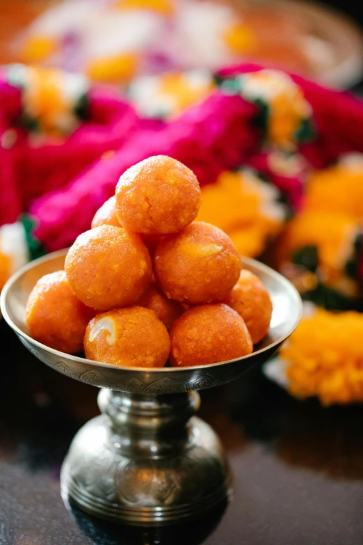 a close up of a bowl of food on a table, hindu ornaments, orange fluffy spines, made out of sweets, bubbly