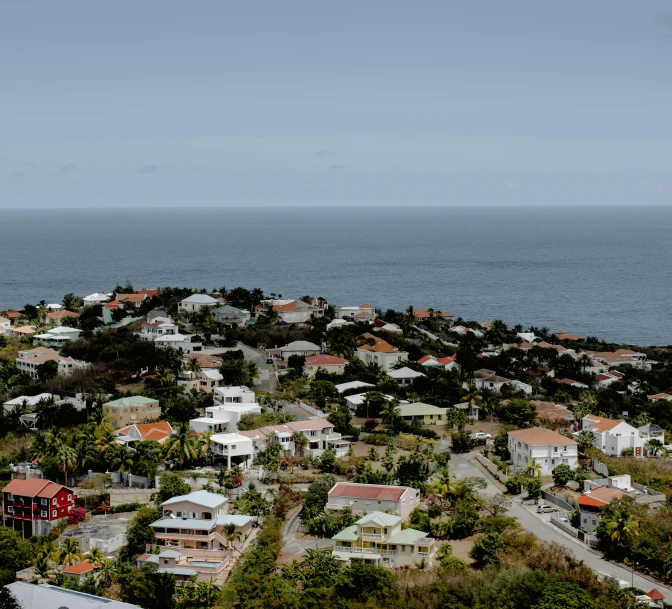 a view of the ocean from the top of a hill, by Carey Morris, pexels, renaissance, residential area, caribbean, grey, panoramic