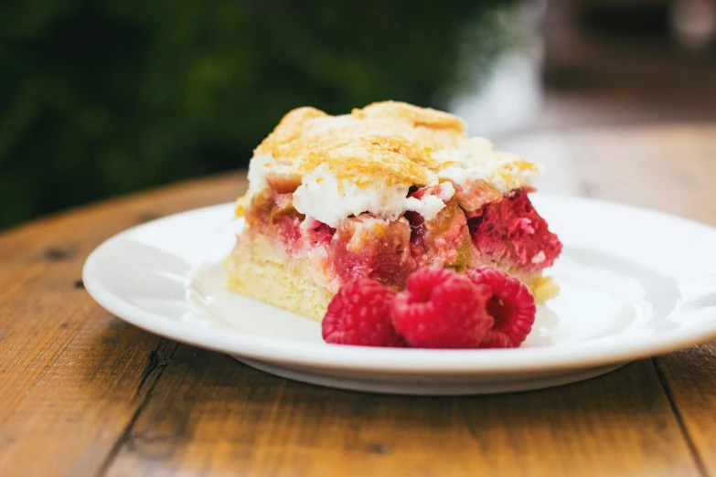 a piece of cake sitting on top of a white plate, unsplash, raspberry, square, a wooden, pink white and green