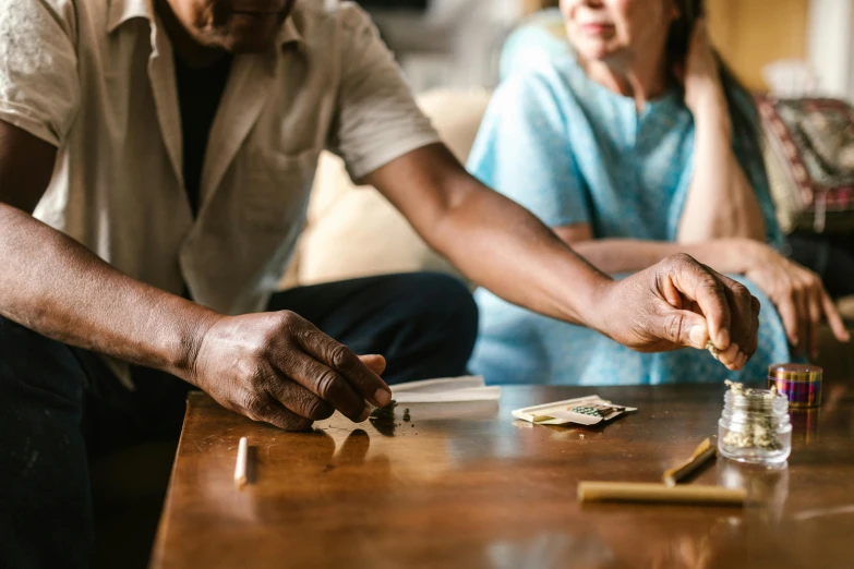 a man and a woman sitting at a table, by Lee Loughridge, pexels contest winner, cardistry, praying with tobacco, at home, thumbnail