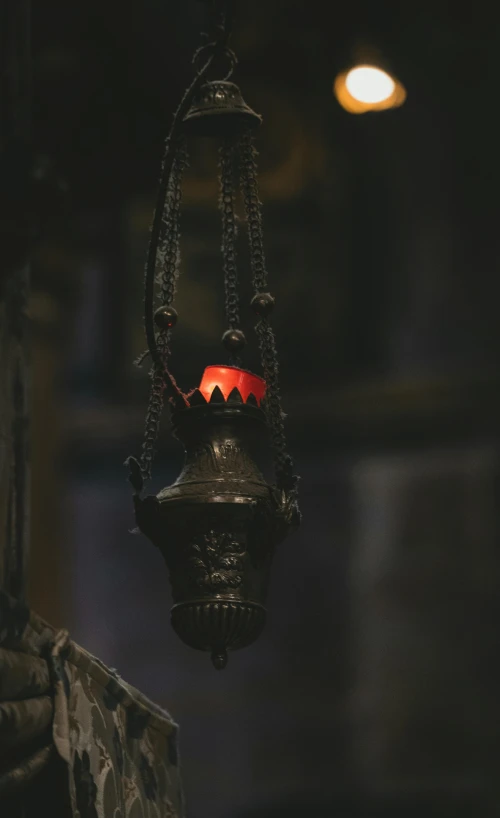 a lantern hanging from a ceiling in a dark room, pexels contest winner, renaissance, substance designer metal, with small object details, lit from below with red lighting, in an ancient altar