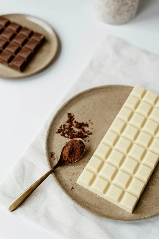 a plate that has a piece of chocolate on it, a still life, inspired by Joris van der Haagen, trending on unsplash, made of all white ceramic tiles, chocolate candy bar packaging, with a soft, chilean