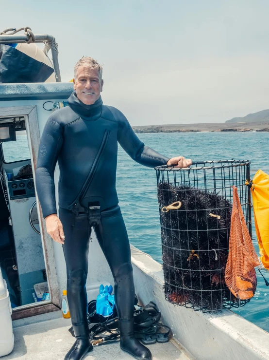 a man in a wet suit standing on a boat, sea sponges, greg irons, an olive skinned, peter hurley