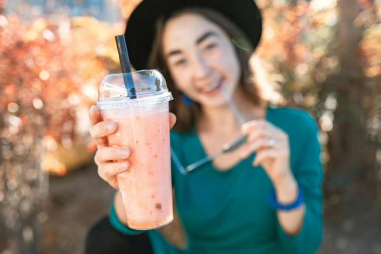 a woman holding a drink in one hand and a straw in the other, pexels contest winner, 🎀 🧟 🍓 🧚, sydney park, berry juice, korean woman