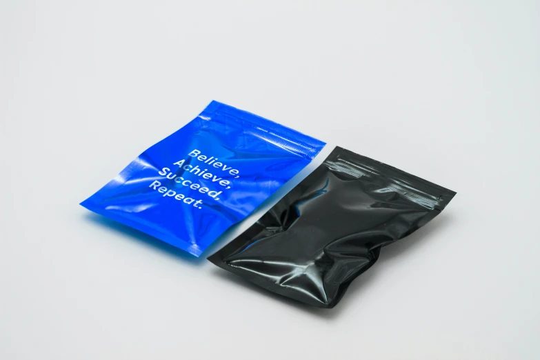 a couple of bags sitting on top of a table, plasticien, black and blue color scheme, nootropic stimulant, back facing, silicone cover