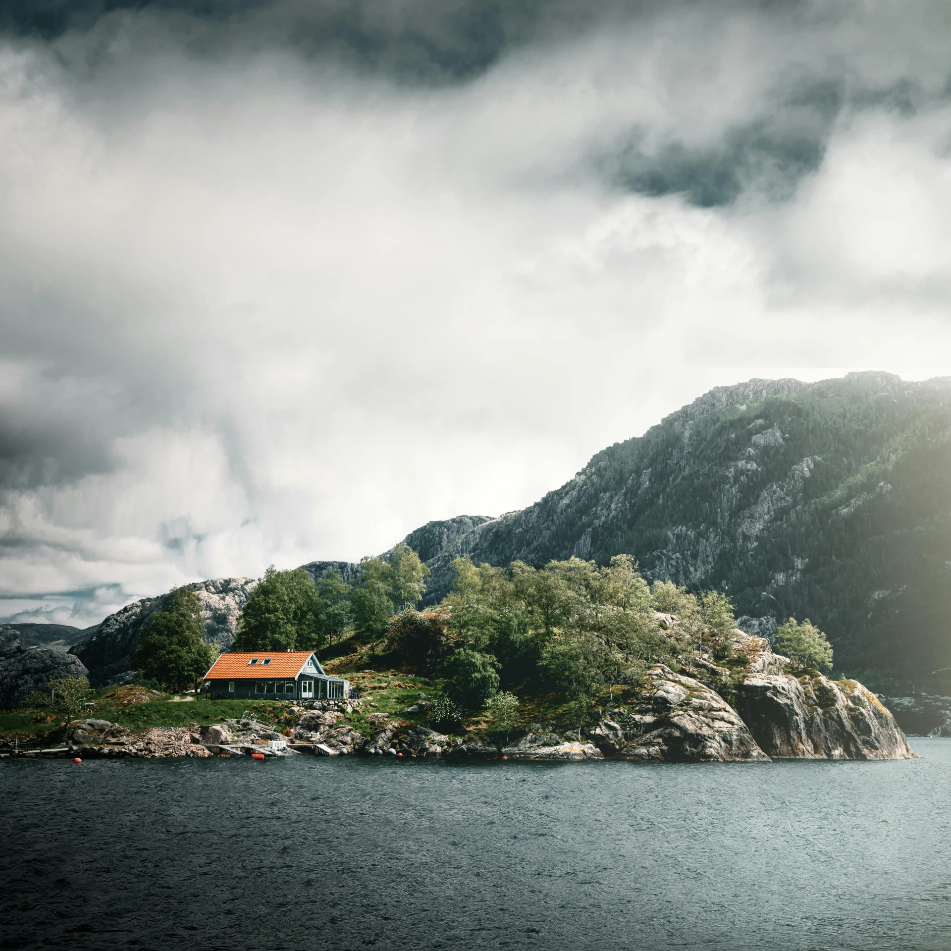 a house sitting on top of a mountain next to a body of water, by Jesper Knudsen, pexels contest winner, modernism, an island, natural overcast lighting, music video, on an island