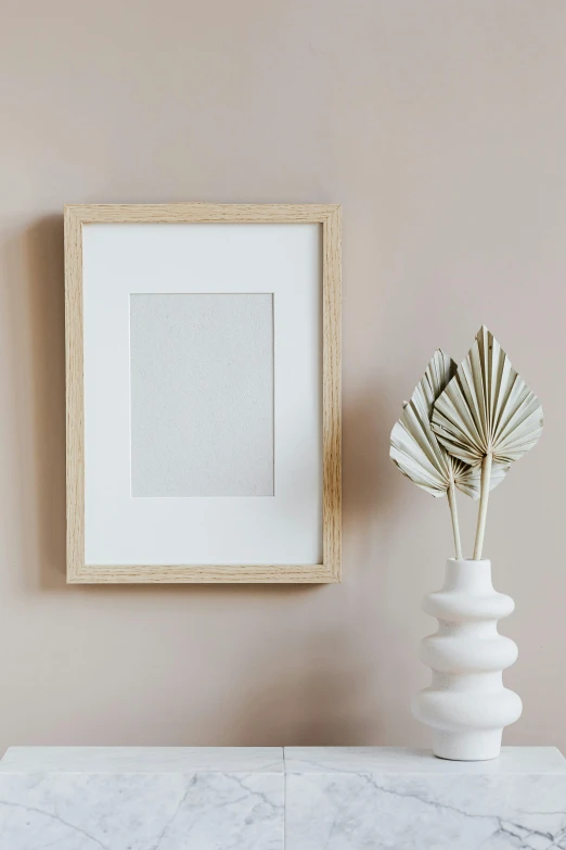 a white vase sitting on top of a table next to a picture frame, a picture, on high-quality paper, ecommerce photograph, paper decoration, product introduction photo