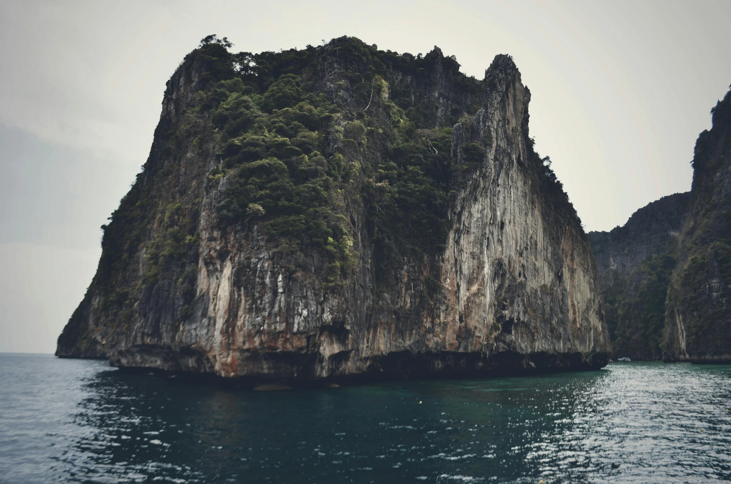 a rock formation in the middle of a body of water, thailand, fan favorite, sunfaded, grey