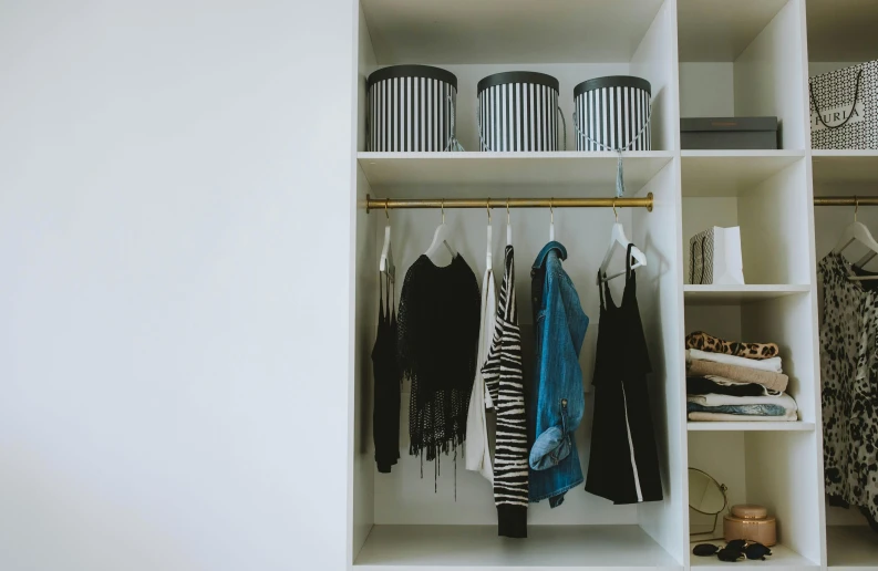 a white closet filled with lots of clothes, by Julia Pishtar, unsplash, gold and black color scheme, slightly sunny weather, shot on sony a 7, dwell