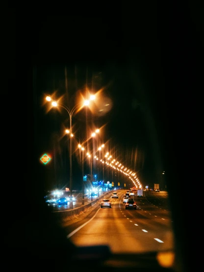 a city street filled with lots of traffic at night, a picture, inspired by Elsa Bleda, unsplash, on a dark desert highway, overexposed flash, photo taken on fujifilm superia, car on highway