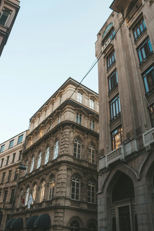 a couple of tall buildings next to each other, a photo, pexels contest winner, renaissance, budapest street background, tall arched stone doorways, fancy apartment, brown