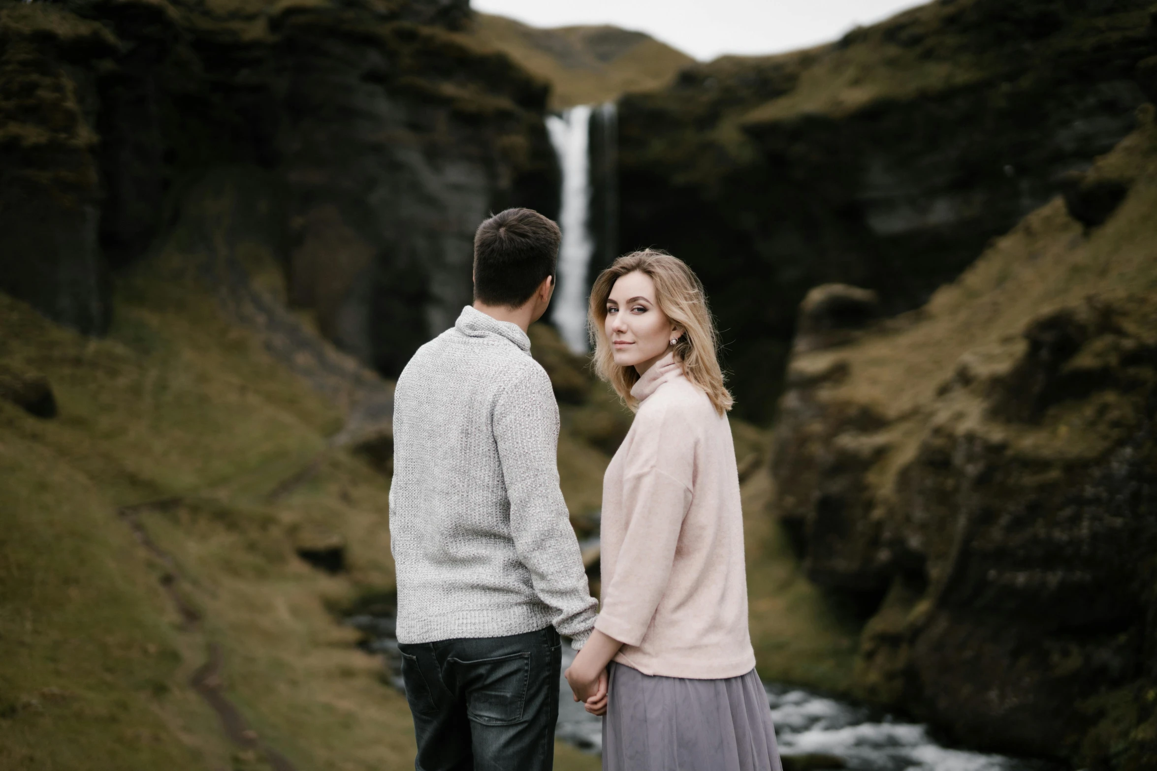 a man and woman standing in front of a waterfall, a portrait, by Hallsteinn Sigurðsson, pexels contest winner, renaissance, grey, romantic couple, thumbnail, iralki nadar