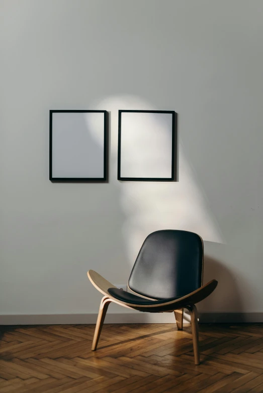 a black chair sitting on top of a wooden floor, poster art, by Harvey Quaytman, trending on unsplash, square pictureframes, diptych, back lit lighting, well contoured smooth fair walls