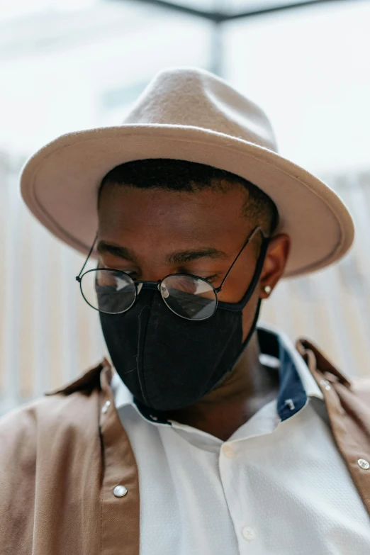 a man wearing a hat, glasses and a face mask, by Carey Morris, trending on pexels, black main color, layers, daniel oxford, haze