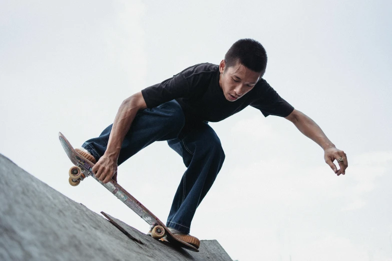 a man riding a skateboard down the side of a ramp, pexels contest winner, asian features, standing on boulder, mechanics, harriet tubman skateboarding