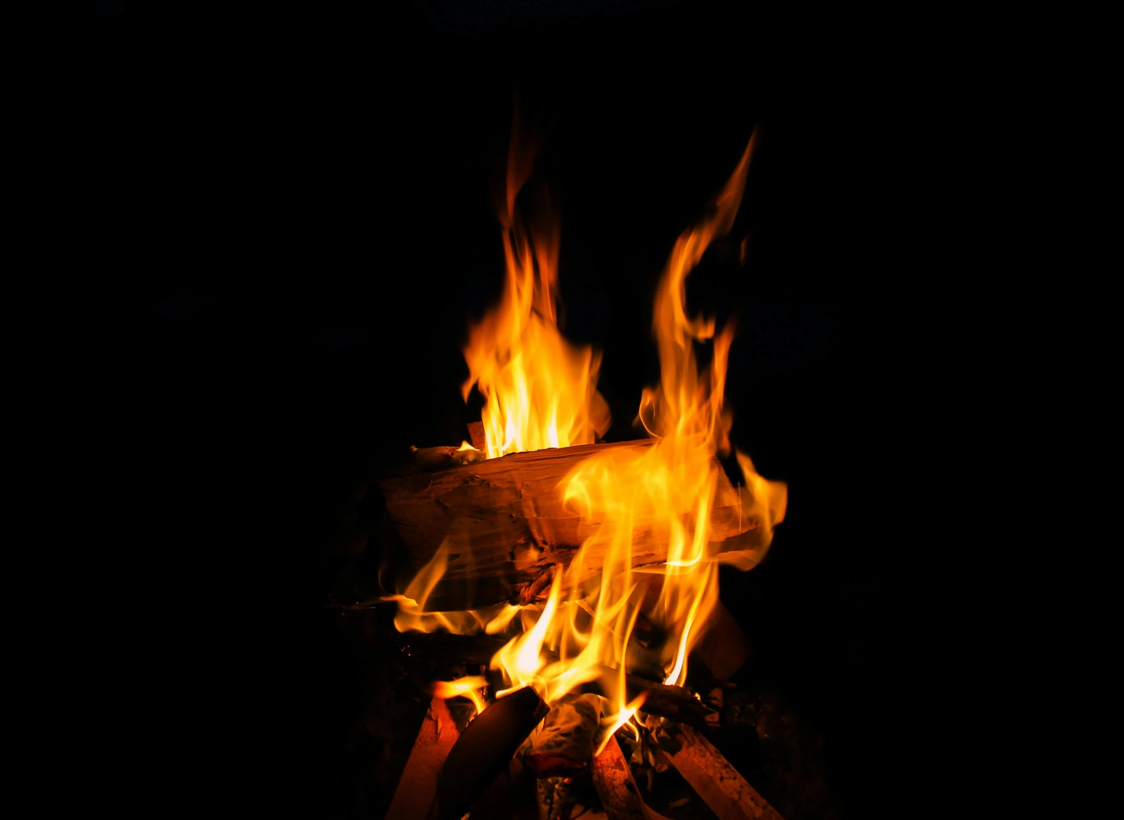 a close up of a fire in the dark, an album cover, pexels, camp, multiple stories, a wooden