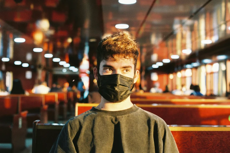 a man wearing a face mask in a restaurant, an album cover, pexels contest winner, lachlan bailey, on ship, teenager, portrait shot 8 k