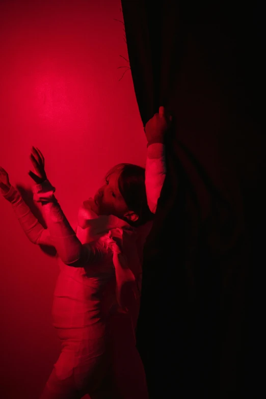 a woman standing in front of a red light, spirits covered in drapery, red lighting on their faces, improvisational, hiding