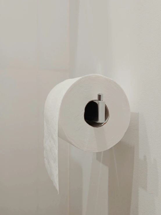 a roll of toilet paper hanging on a wall, by Andries Stock, unsplash, happening, low quality footage, taken on iphone 14 pro, jovana rikalo, toiletpaper magazine