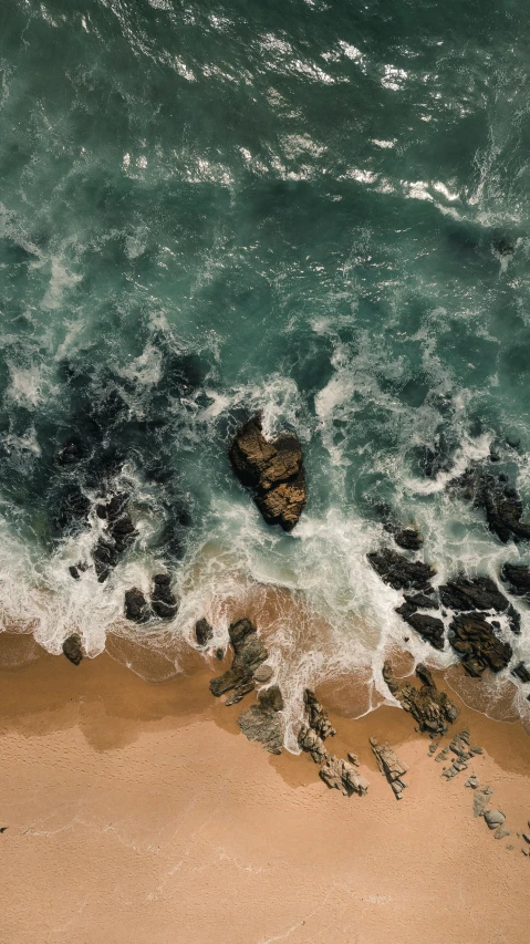 a large body of water next to a sandy beach, by Robbie Trevino, pexels, mid air shot, rough sea, unsplash photo contest winner, multiple stories