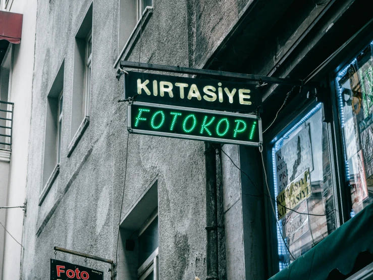 a street sign hanging from the side of a building, krzysztof porchowski jr, avatar image, neon sign, multiple stories