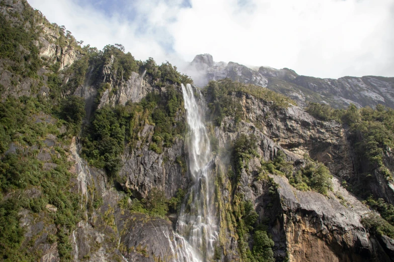 a waterfall flowing down the side of a mountain, by Peter Churcher, hurufiyya, avatar image, chilean, thumbnail, multiple stories