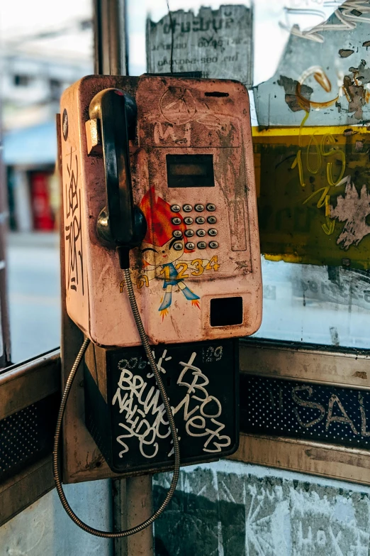 an old pay phone sitting on top of a glass table, a photo, trending on pexels, graffiti, square, as well as scratches, brown, kreuzberg