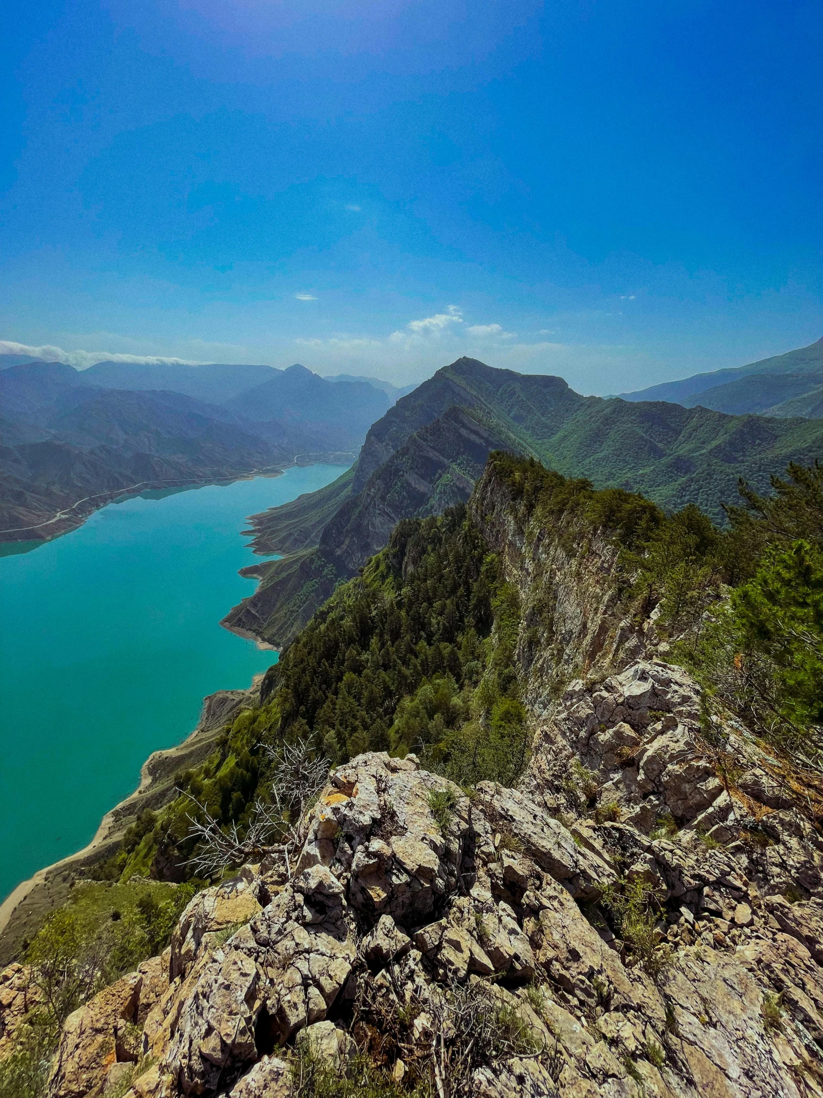 a view of a lake from the top of a mountain, by Cedric Peyravernay, hurufiyya, slide show, blue and green water, brown, mountainous