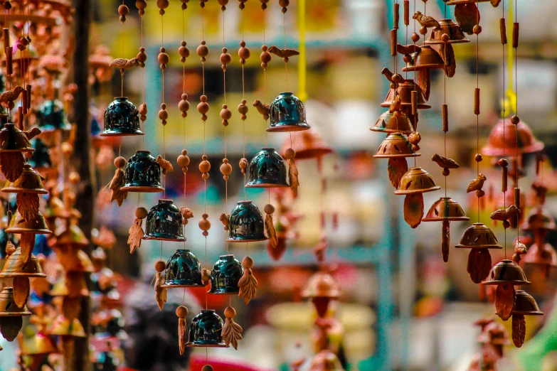 a bunch of figurines hanging from a ceiling, a tilt shift photo, pexels contest winner, cloisonnism, indore, exterior shot, 🦩🪐🐞👩🏻🦳, bells