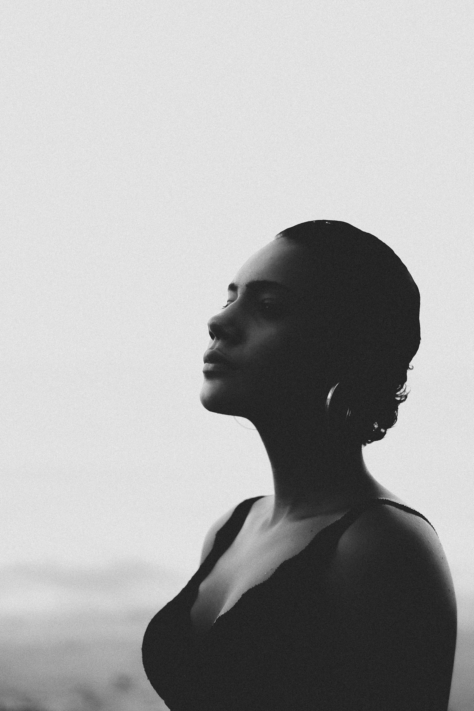 a black and white photo of a woman, unsplash, r&b, posed in profile, meditative, photo of a black woman