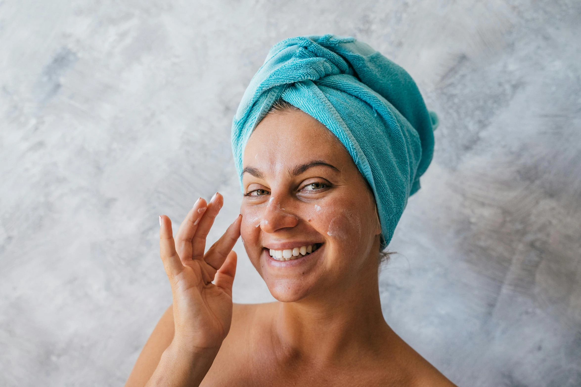 a woman with a blue towel on her head, a stipple, trending on pexels, renaissance, smiling woman, manuka, silicone skin, covered in oil