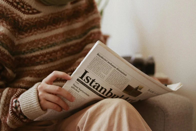 a person sitting on a couch reading a newspaper, trending on pexels, private press, fallout style istanbul, student, intarsia, hollywood standard