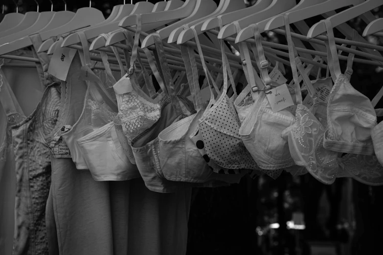 a black and white photo of bras hanging on a rack, a photo, by Kristian Kreković, cinematic. by leng jun, white bra, summer season, masks