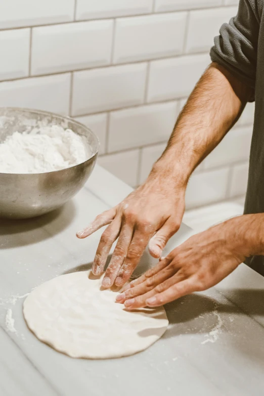 a close up of a person kning dough on a counter, by Daren Bader, dustin panzino, thumbnail, crispy, seattle